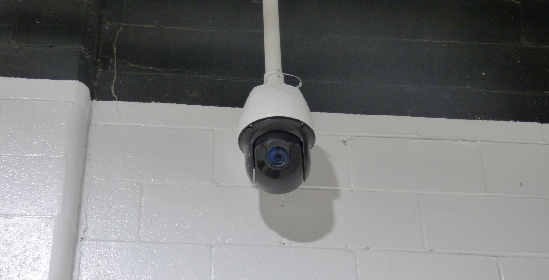 White PTZ camera hanging from a pendant
