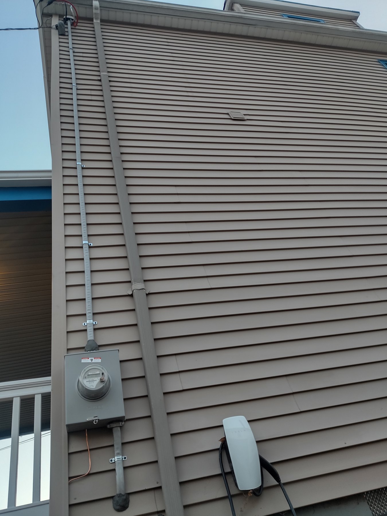 Meter, conduit riser, and a car charger on house siding