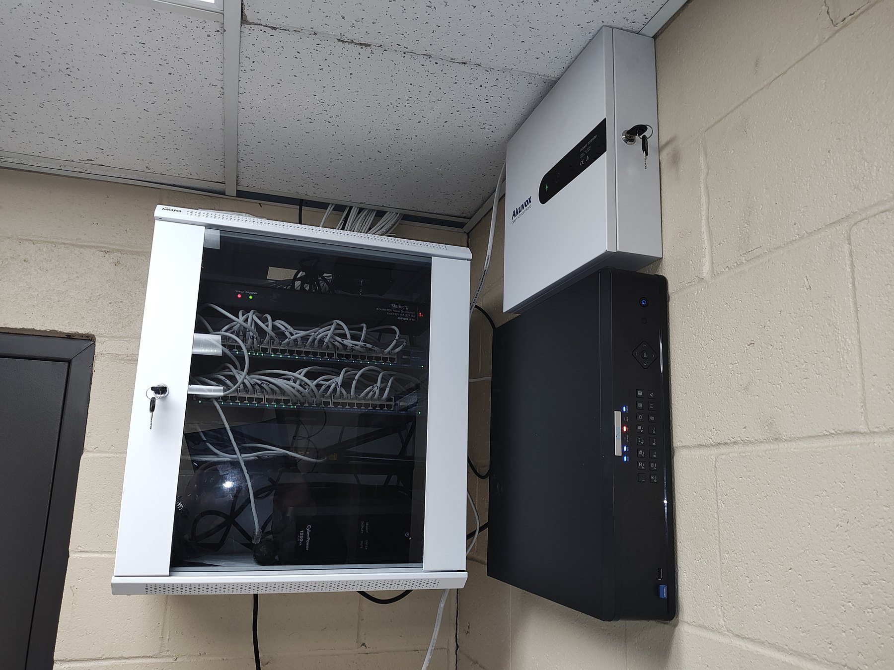 Network cabinet, Ajax panel, and camera recorder mounted on a block wall