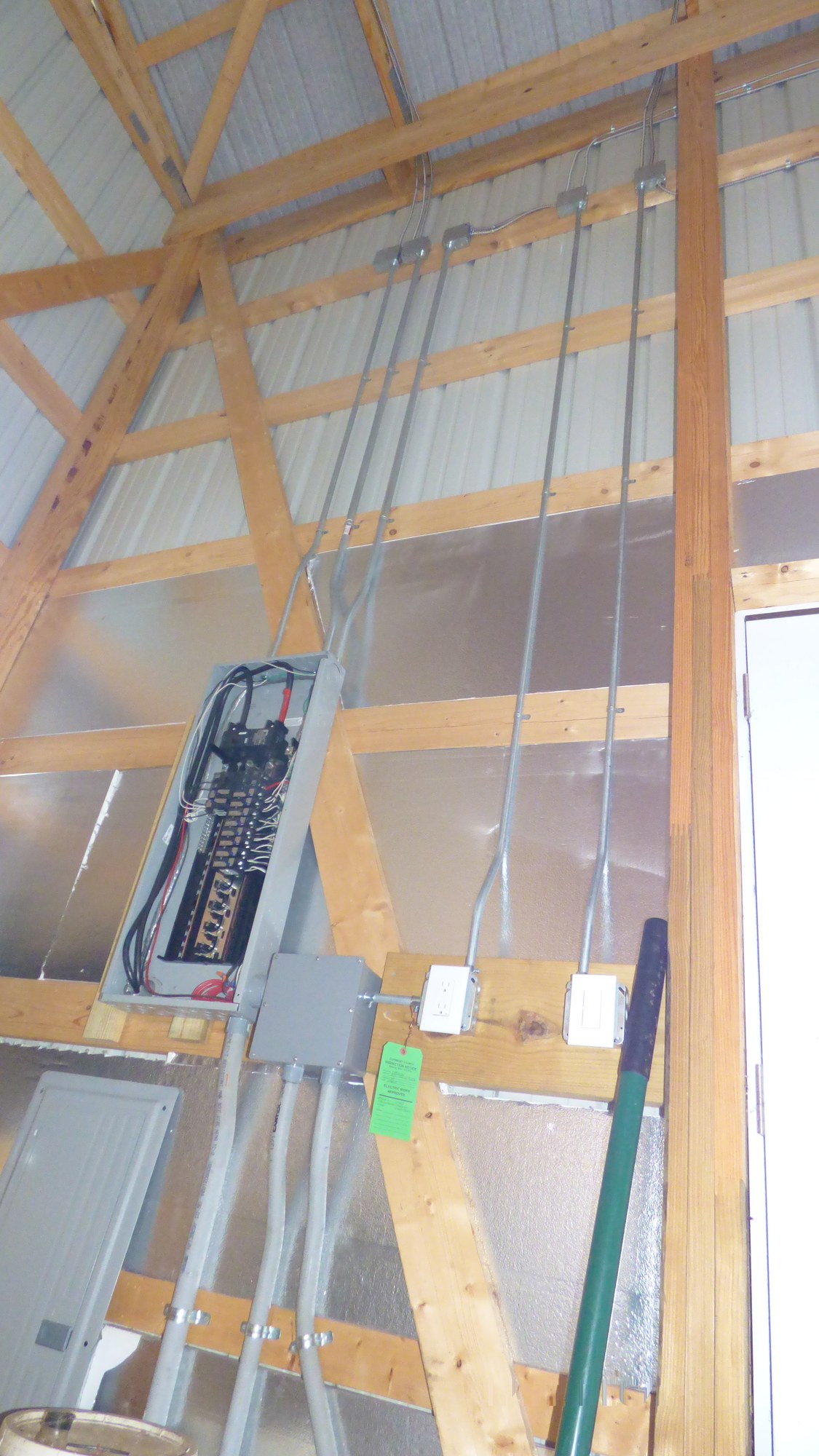 Shop wall with conduit runs, an open panel, and outlets TEK installed